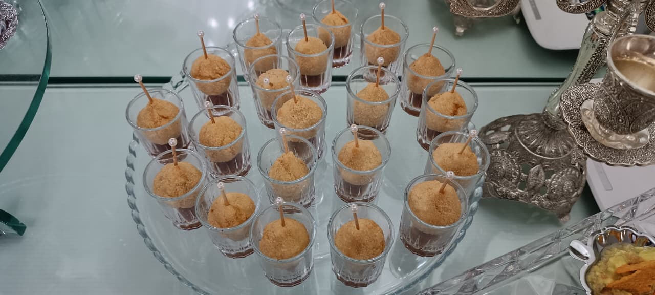 Copinhos de doce com palito servidos em bandeja de vidro