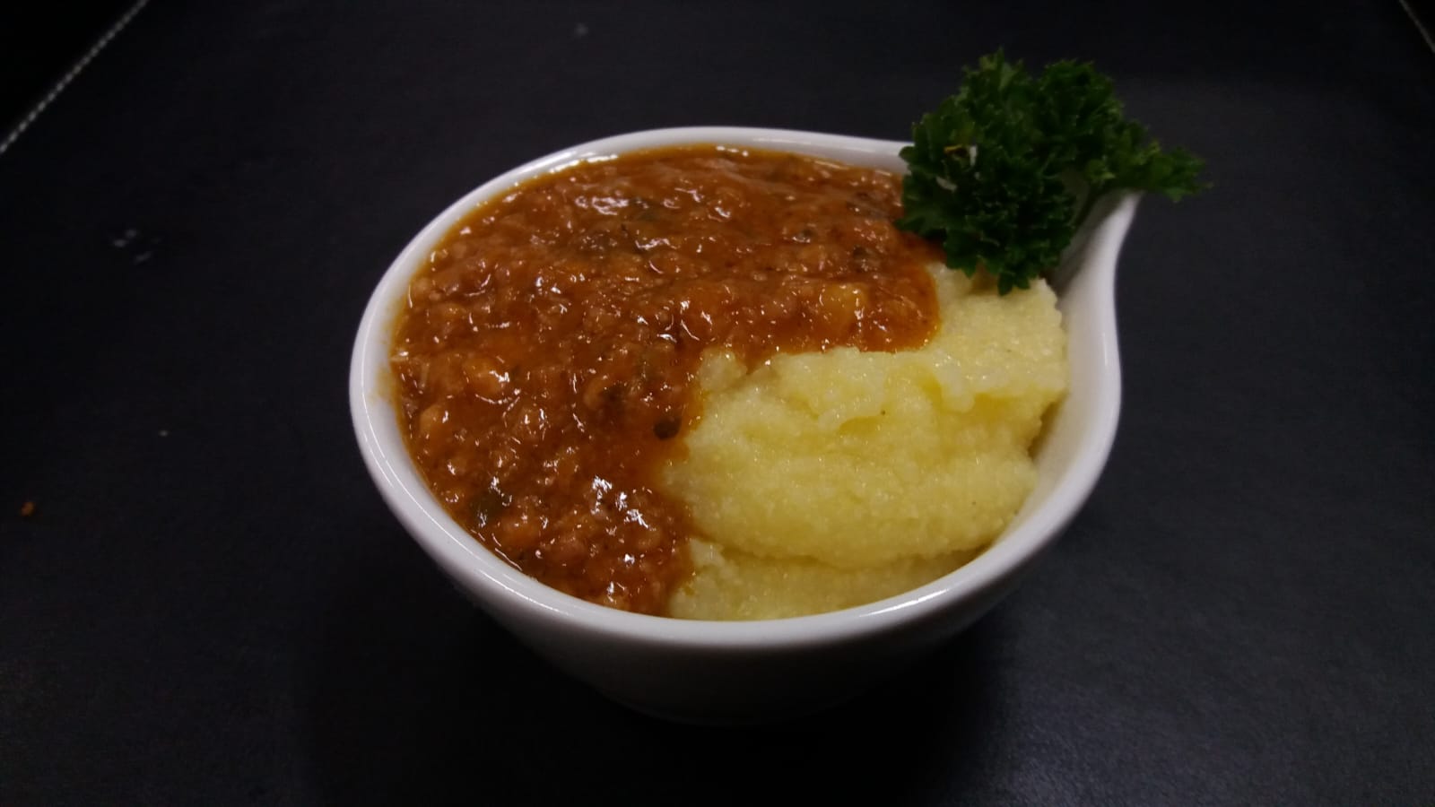 Porção individual de polenta cremosa com ragu servida pela Demi Glace Gastronomia